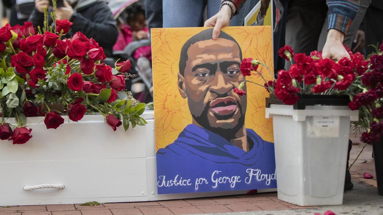 Portrait von George Floyd bei einem Gedenkmarsch einen Tag vor Prozessbeginn