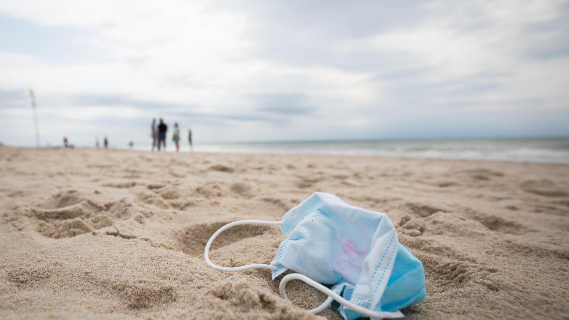 11.06.2020, Schleswig-Holstein, Westerland/Sylt: Ein gebrauchter Mundschutz mit Resten von Lippenstift liegt am Strand vor der Strandpromenade von Westerland auf Sylt. Schleswig-Holsteins Ministerpräsident Günther besuchte am Donnerstag die Nordseeinsel um sich ein Bild von der aktuellen Lage auf der Insel zu machen. (zu dpa «»Sehr diszipliniert« - Sylt gut vorbereitet für Saison») Foto: Christian Charisius/dpa | Verwendung weltweit 11.06.2020, Schleswig-Holstein, Westerland/Sylt: Ein gebrauchter Mundschutz mit Resten von Lippenstift liegt am Strand vor der Strandpromenade von Westerland auf Sylt. Schleswig-Holsteins Ministerpräsident Günther besuchte am Donnerstag die Nordseeinsel um sich ein Bild von der aktuellen Lage auf der Insel zu machen. (zu dpa «»Sehr diszipliniert« - Sylt gut vorbereitet für Saison») Foto: Christian Charisius/dpa | Verwendung weltweit