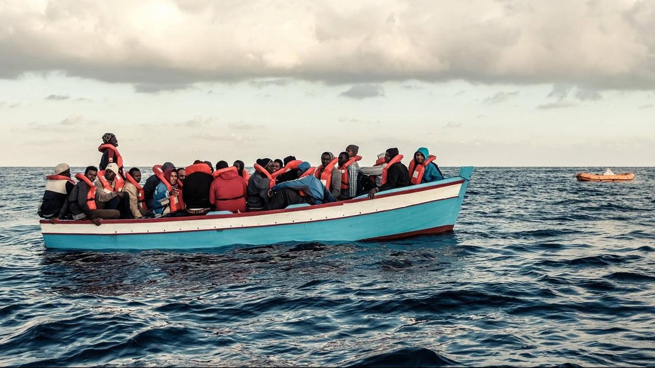 Ein vollbesetztes Flüchtlingsboot mit Flüchtlingen treibt auf dem Meer westlich von Tripolis Ein vollbesetztes Flüchtlingsboot mit Flüchtlingen treibt auf dem Meer westlich von Tripolis