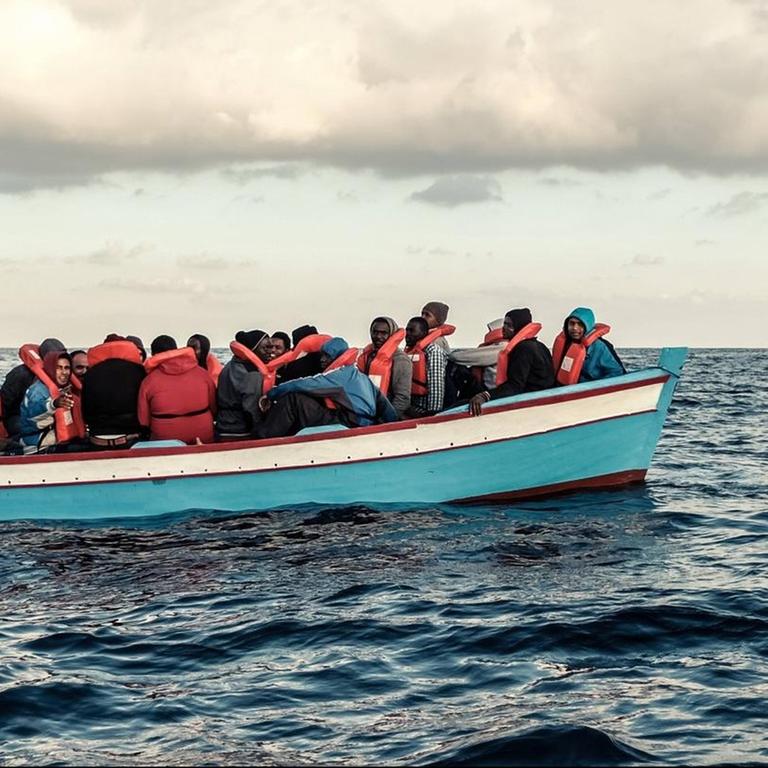 Ein vollbesetztes Flüchtlingsboot mit Flüchtlingen treibt auf dem Meer westlich von Tripolis