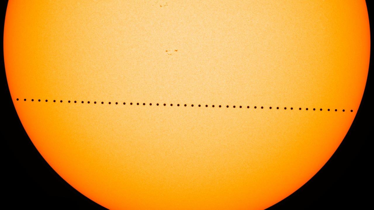 Vor der Sonnenscheibe ist der Merkur als kleiner schwarzer Punkt zu erkennen.