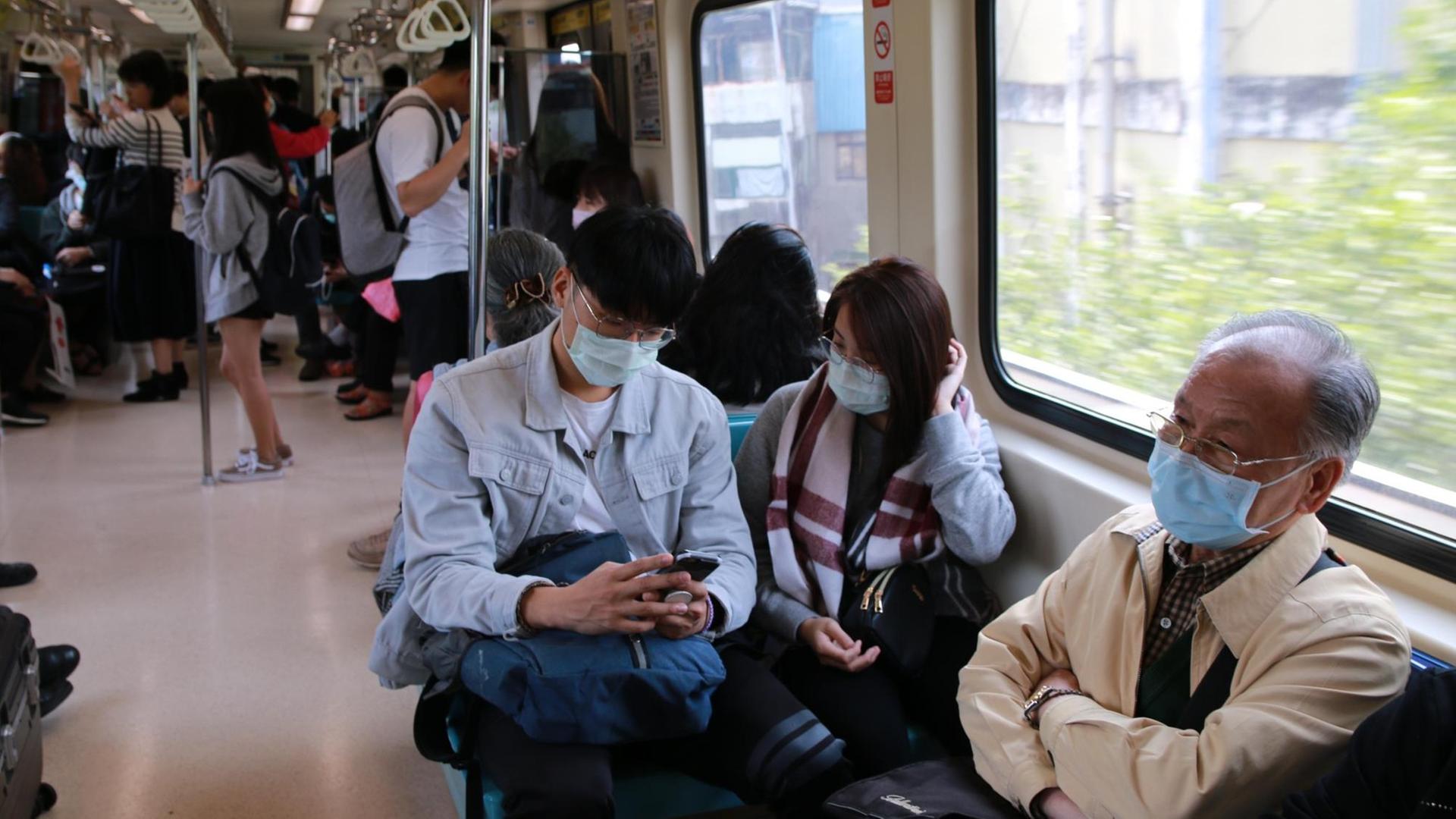 Menschen tragen Mundschutz in der Metro von Taipeh Menschen tragen Mundschutz in der Metro von Taipeh