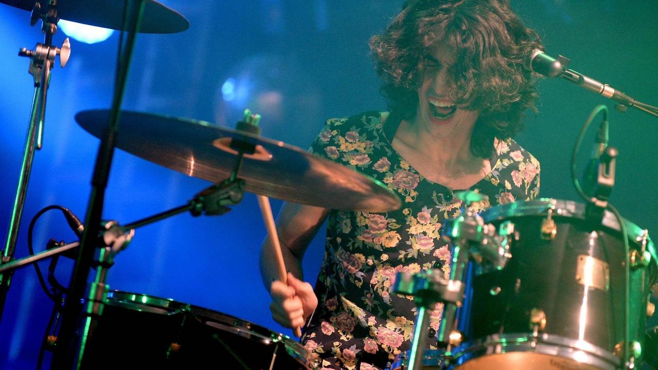 Liv Bruce von PWR BTTM trägt ein Blumenkleid und spielt Schlagzeug