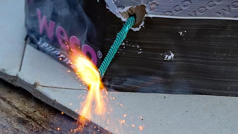 Brennende Zündschnur an einem Feuerwerkskörper der Firma Weco Brennende Zündschnur an einem Feuerwerkskörper der Firma Weco