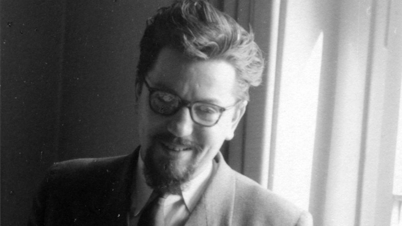 Der Komponist Bernd Alois Zimmermann steht vor einem Fenster, raucht und lächelt. Der Komponist Bernd Alois Zimmermann steht vor einem Fenster, raucht und lächelt.
