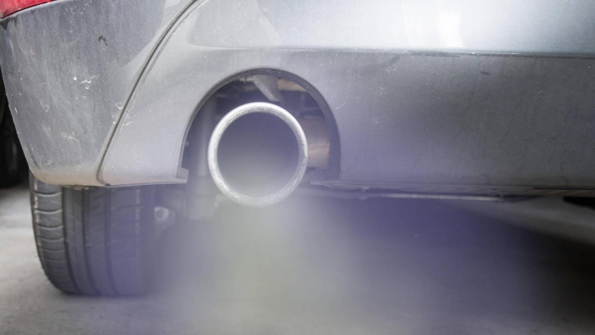 Rauch strömt aus dem Auspuff eines Autos Rauch strömt aus dem Auspuff eines Autos