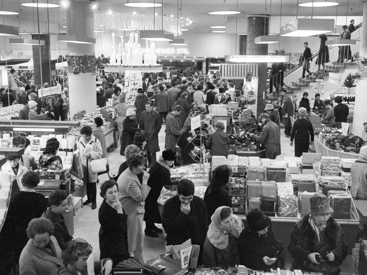 Blick in ein Frankfurter Kaufhaus am 3.12.1963, Schwarz-Weiß-Aufnahme, Menschen stehen an Kassen und Verkaufsständen Blick in ein Frankfurter Kaufhaus am 3.12.1963, Schwarz-Weiß-Aufnahme, Menschen stehen an Kassen und Verkaufsständen