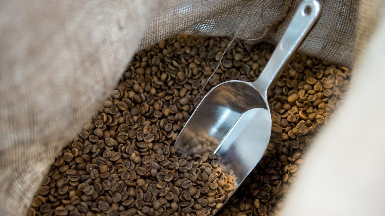 Eine Schaufel steckt in einem Kaffeesack. Eine Schaufel steckt in einem Kaffeesack.