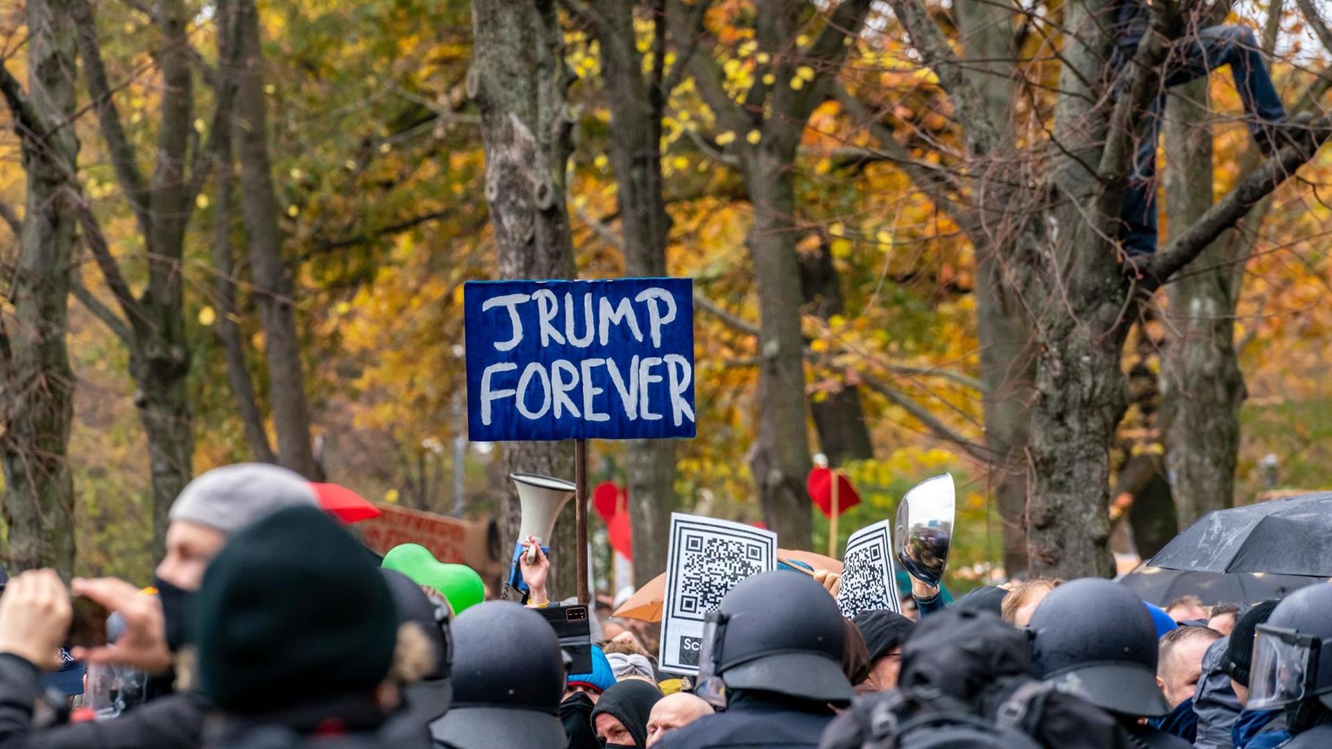 Nicht genehmigte Demonstration der Querdenken-Bewegung am. 18. November 2020 in Berlin. Vor einer herbstlichen Kulisse halten Demonstranten ein Schild "Trump forever" in die Höhe. Nicht genehmigte Demonstration der Querdenken-Bewegung am. 18. November 2020 in Berlin. Vor einer herbstlichen Kulisse halten Demonstranten ein Schild "Trump forever" in die Höhe.