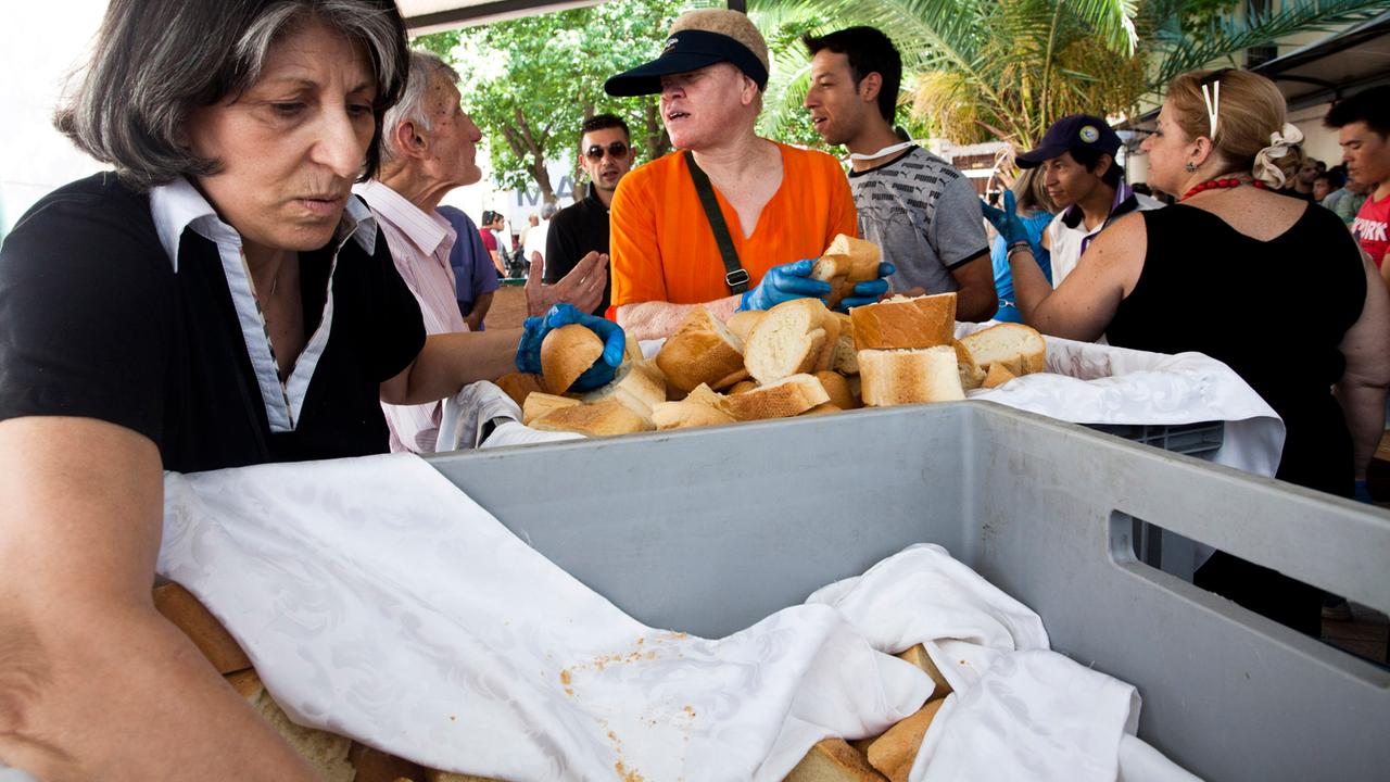Zu sehen ist eine Essensausgabe in Athen. Einheimische und Migranten erhalten von freiwilligen Helfern Lebensmittel. Zu sehen ist eine Essensausgabe in Athen. Einheimische und Migranten erhalten von freiwilligen Helfern Lebensmittel.
