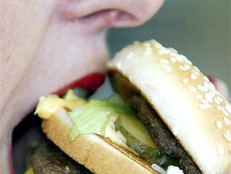 Eine Frau beißt in einen Big Mäc in einem Mc-Donald's-Restaurant in Düsseldorf Eine Frau beißt in einen Big Mäc in einem Mc-Donald's-Restaurant in Düsseldorf