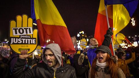 Menschen protestieren in der rumänischen Hauptstadt mit Fahnen in den Landesfarben und mit Slogans gegen die geplante Justizreform
