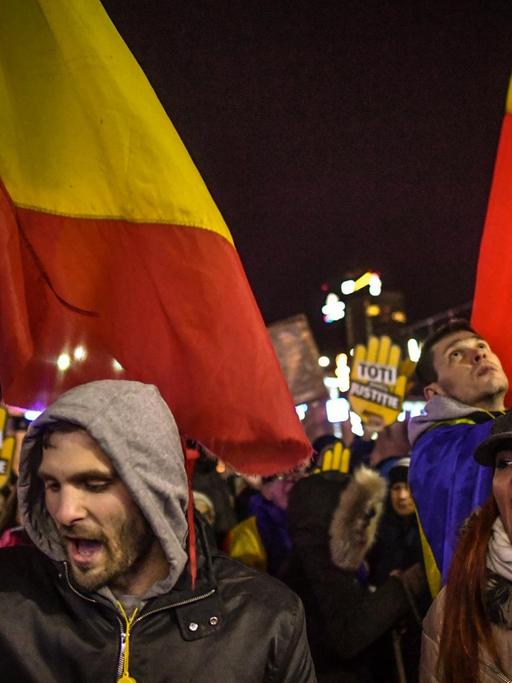 Menschen protestieren in der rumänischen Hauptstadt mit Fahnen in den Landesfarben und mit Slogans gegen die geplante Justizreform