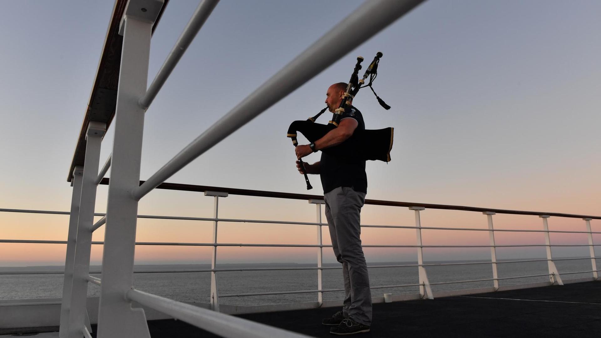 Ein Dudelsackspieler am Bord des britischen Kreuzfahrtschiffs RMS Queen Mary 2 im Atlantik Ein Dudelsackspieler am Bord des britischen Kreuzfahrtschiffs RMS Queen Mary 2 im Atlantik