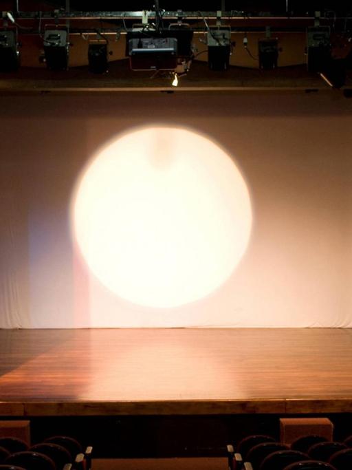Leere Theaterbühne mit rotem Vorhang.