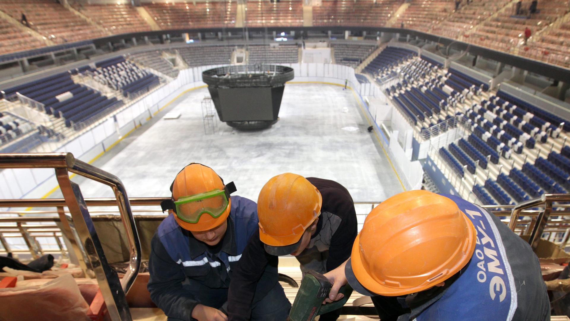 Drei Arbeiter schreiben in der Chizhovka-Arena eine Treppe fest. Die Multifunktionshalle ist einer der Austragungsorte der Eishockey-WM 2014.
