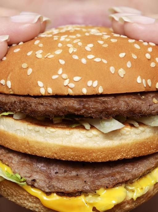 Eine Frau beißt in einen Cheeseburger.