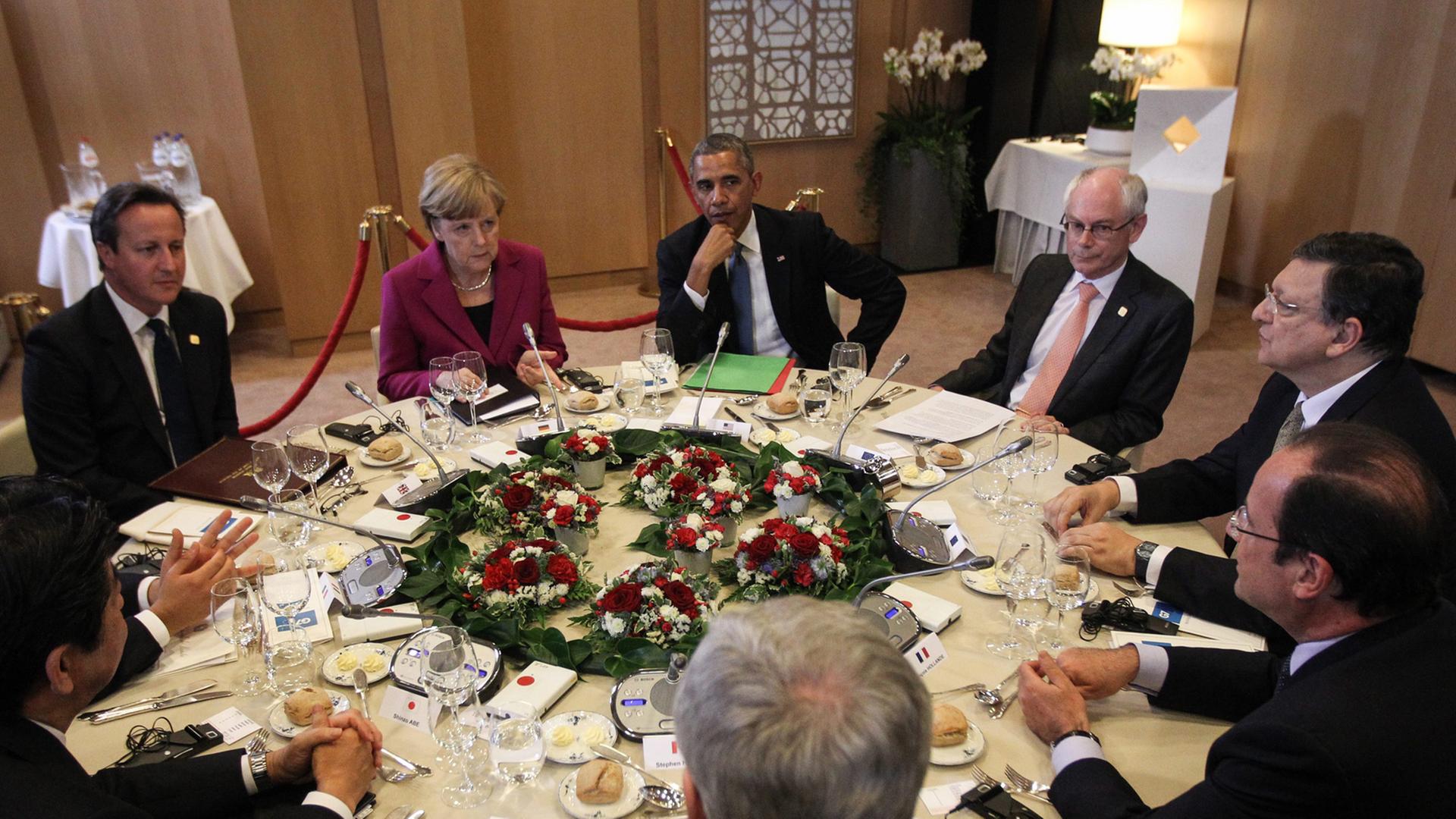 Die Staats- und Regierungschefs der sieben führenden Industrienationen sitzen gemeinsam an einem runden Tisch.