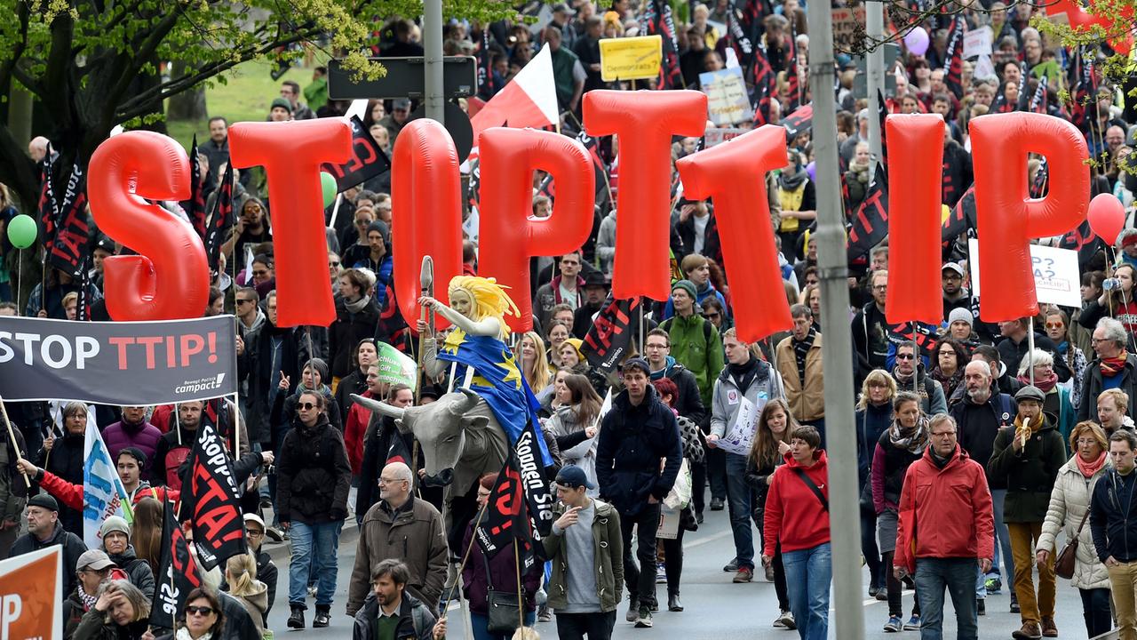 Demonstranten tragen am 23.04.2016 Fahnen und Banner während einer Demonstration gegen das umstrittene transatlantische Freihandelsabkommen TTIP in Hannover. Demonstranten tragen am 23.04.2016 Fahnen und Banner während einer Demonstration gegen das umstrittene transatlantische Freihandelsabkommen TTIP in Hannover.