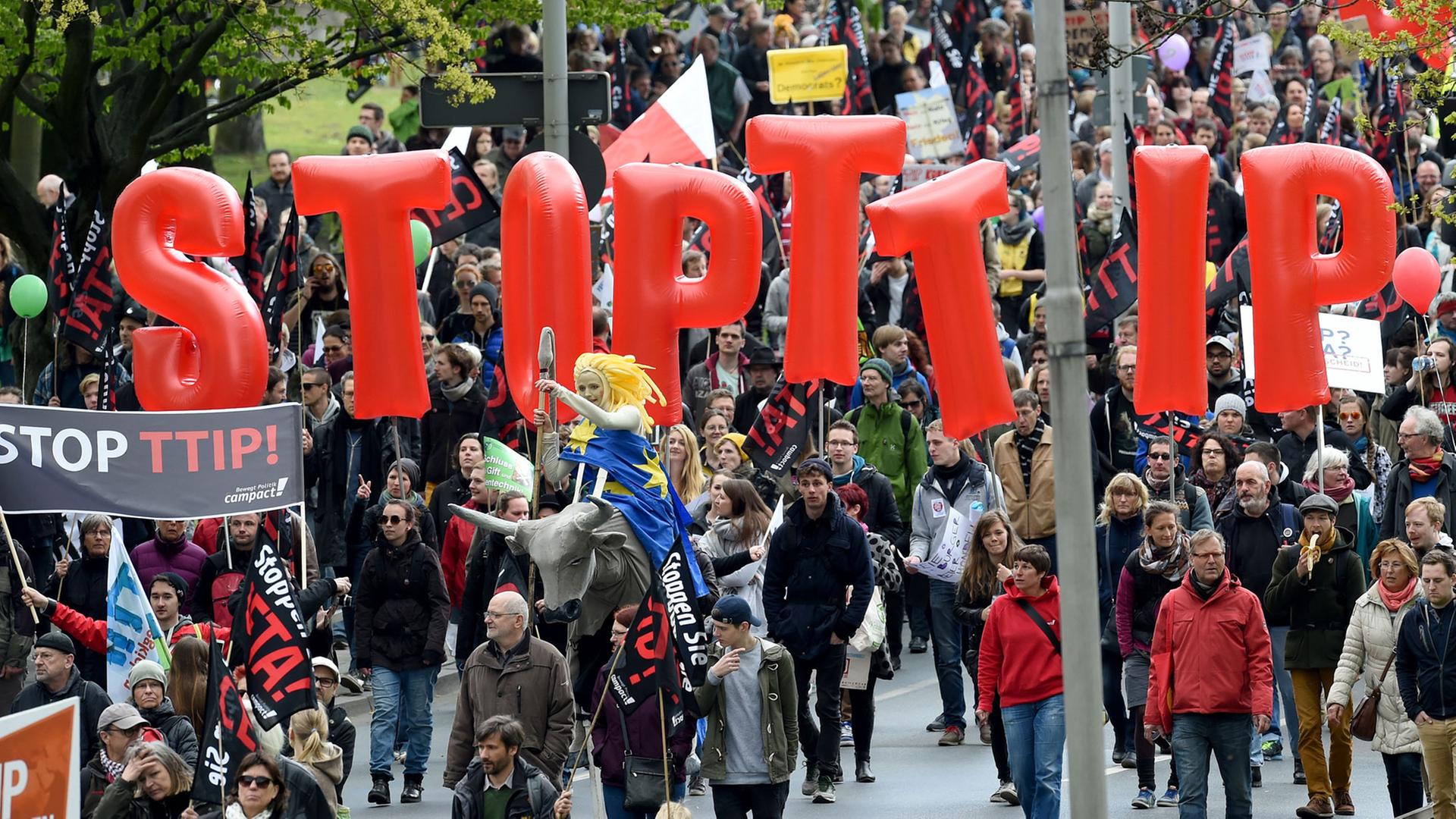 Demonstranten tragen am 23.04.2016 Fahnen und Banner während einer Demonstration gegen das umstrittene transatlantische Freihandelsabkommen TTIP in Hannover. Demonstranten tragen am 23.04.2016 Fahnen und Banner während einer Demonstration gegen das umstrittene transatlantische Freihandelsabkommen TTIP in Hannover.