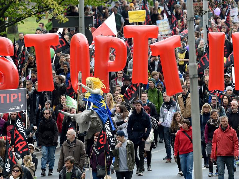 Demonstranten tragen am 23.04.2016 Fahnen und Banner während einer Demonstration gegen das umstrittene transatlantische Freihandelsabkommen TTIP in Hannover.