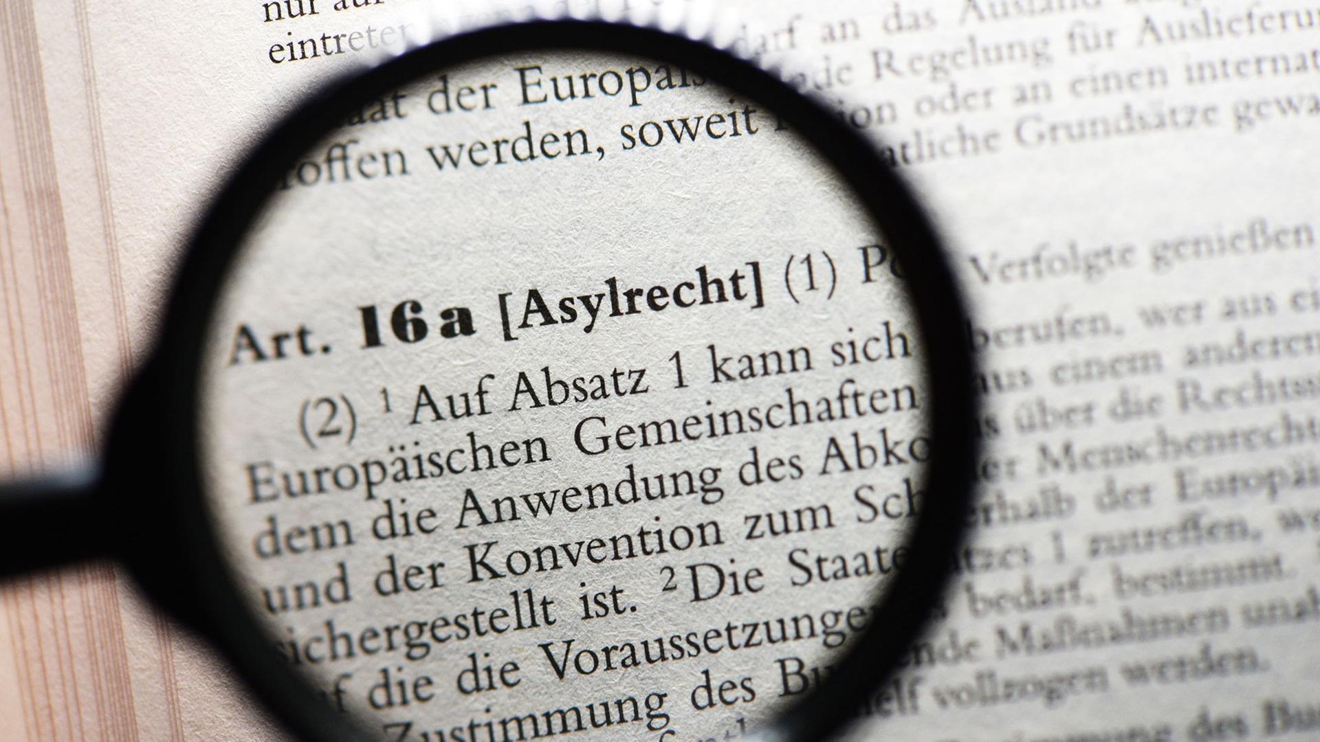Blick durch eine Lupe auf Artikel 16a des Grundgesetzes zum Asylrecht