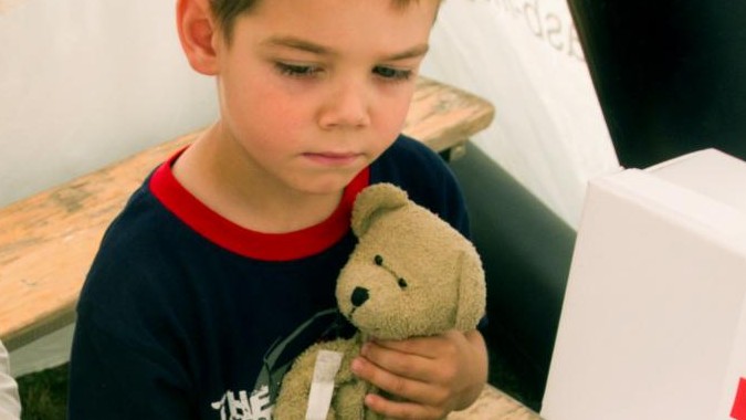 Zu sehen ist ein Junge mit seinem Teddy auf dem Arm Zu sehen ist ein Junge mit seinem Teddy auf dem Arm