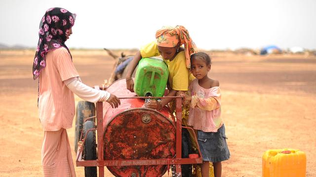 Drei Mädchen aus Mali holen Wasser in einem Flüchtlingscamp in der Nähe von Dori, Burkina Faso.