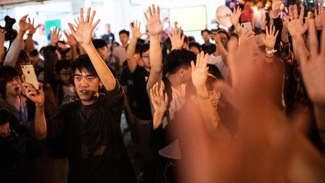 Unterstützer der pro-demokratischen Bewegung stecken auf der Straße feiernd die Hände in die Höhe.