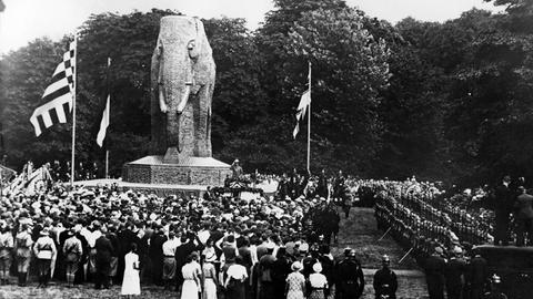 Historisches Schwarz-Weiß-Bild einer Festgesellschaft, die in Bremen um ein Denkmal in Form eines großen steinernen Elefanten versammelt.
