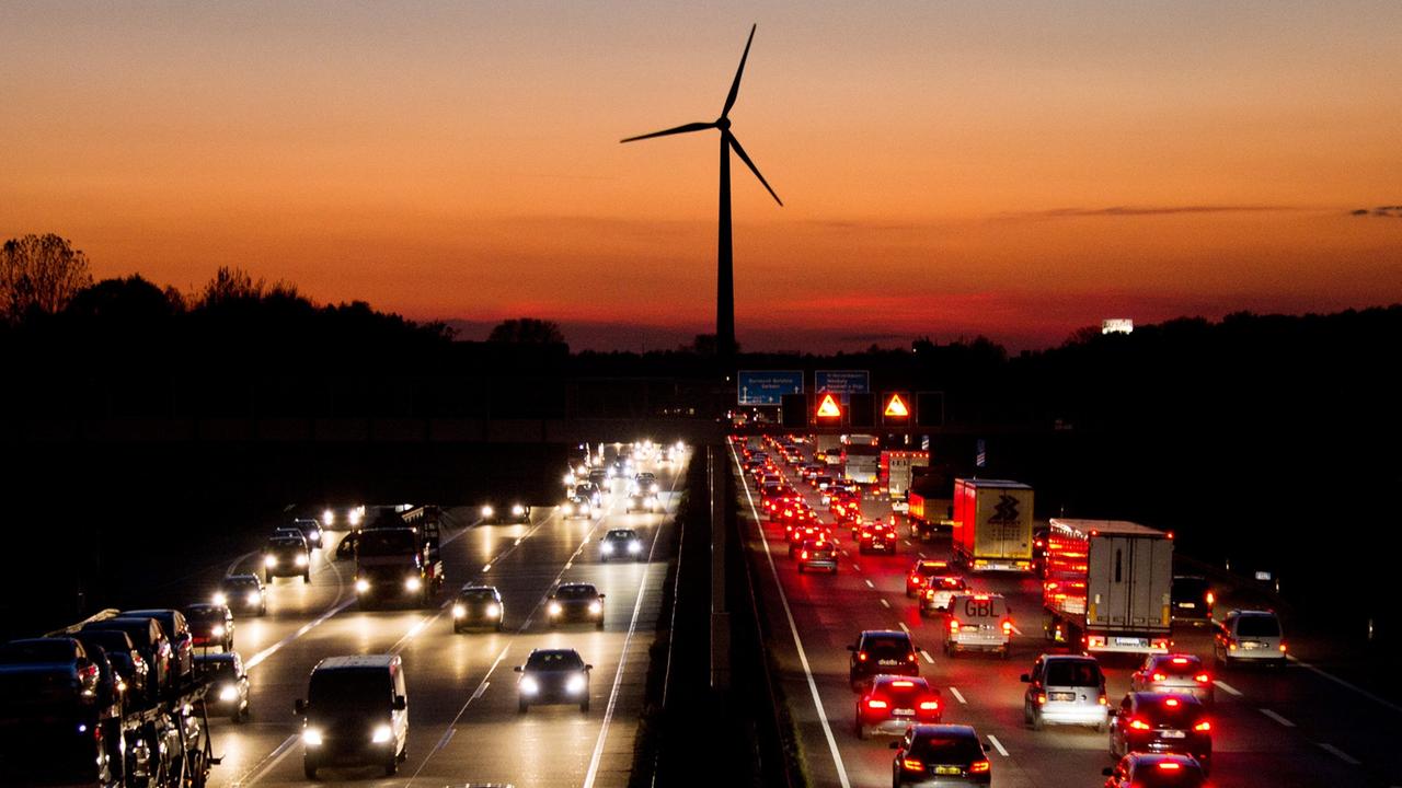 Die Autobahn 2 abends, dahinter ein Windrad Die Autobahn 2 abends, dahinter ein Windrad