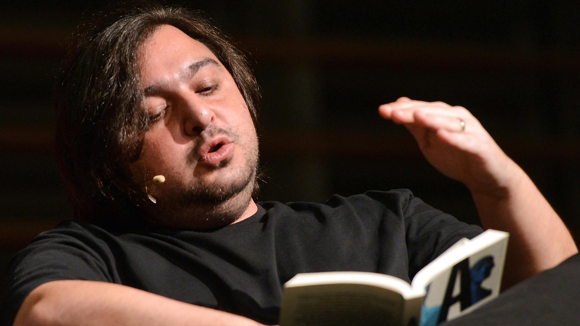 Der Autor Hakan Günday sitzt am 14.03.2014 bei einer Lesung im Rahmen des Literaturfestivals lit.Cologne in Köln (Nordrhein-Westfalen) auf der Bühne, wo er sein Buch "Extrem" vorstellt. Der Autor Hakan Günday sitzt am 14.03.2014 bei einer Lesung im Rahmen des Literaturfestivals lit.Cologne in Köln (Nordrhein-Westfalen) auf der Bühne, wo er sein Buch "Extrem" vorstellt.