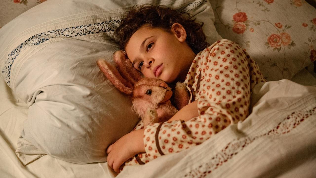 Filmstill aus dem neuen Film: "Als Hitler das rosa Kaninchen stahl", die Hauptdarstellerin Riva Krymalowski liegt mit einem Stoffhasen im Arm im Bett.