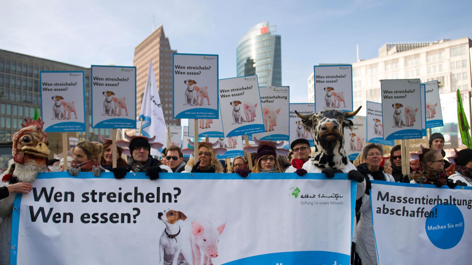 Demonstrationsteilnehmer marschieren mit einem Plakat mit der Aufschrift "Wen streicheln? Wen essen?". Demonstrationsteilnehmer marschieren mit einem Plakat mit der Aufschrift "Wen streicheln? Wen essen?".