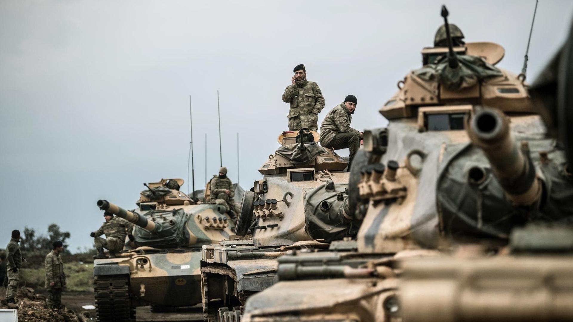 Mehrere türkische Panzer fahren über eine staubige Straße Mehrere türkische Panzer fahren über eine staubige Straße