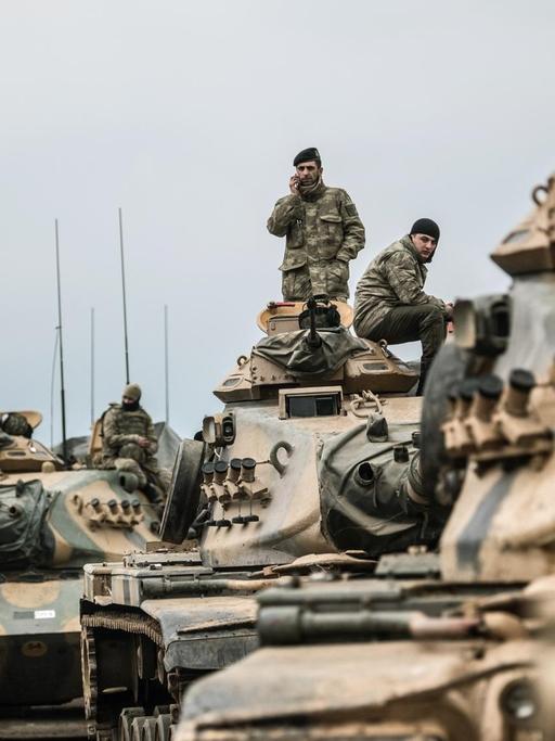 Mehrere türkische Panzer fahren über eine staubige Straße