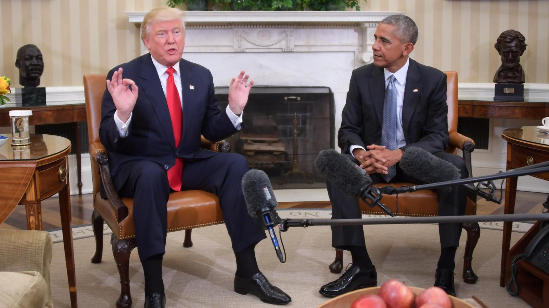 US-Präsident Barack Obama (r) und sein gewählter Nachfolger Donald Trump (l) sitzen nebeneinander auf Sesseln im Weißen Haus. US-Präsident Barack Obama (r) und sein gewählter Nachfolger Donald Trump (l) sitzen nebeneinander auf Sesseln im Weißen Haus.