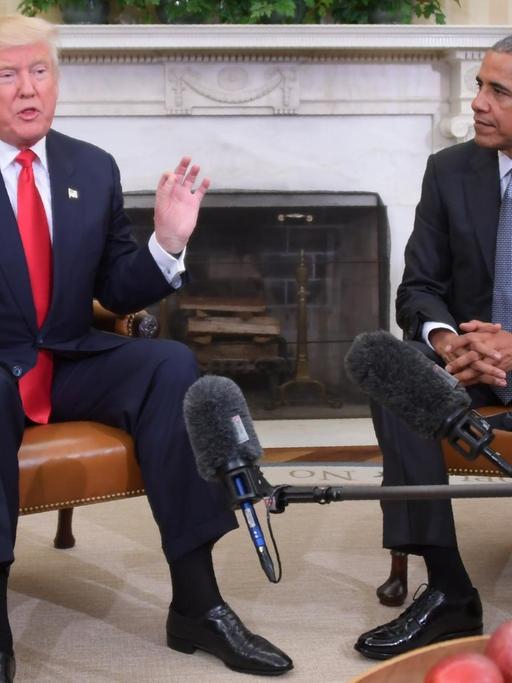 US-Präsident Barack Obama (r) und sein gewählter Nachfolger Donald Trump (l) sitzen nebeneinander auf Sesseln im Weißen Haus.