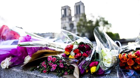 Blumen liegen vor Notre-Dame in Paris.