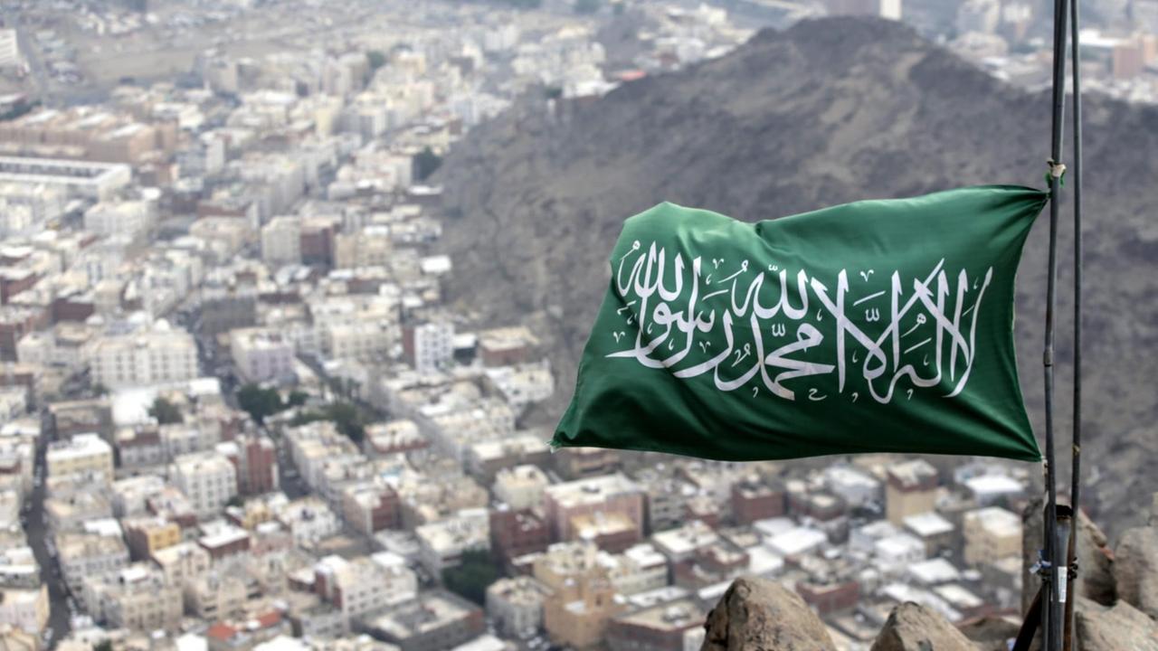 Eine saudi-arabische Fahne weht auf dem Berg Hira. Dahinter sind Häuser zu sehen. Eine saudi-arabische Fahne weht auf dem Berg Hira. Dahinter sind Häuser zu sehen.