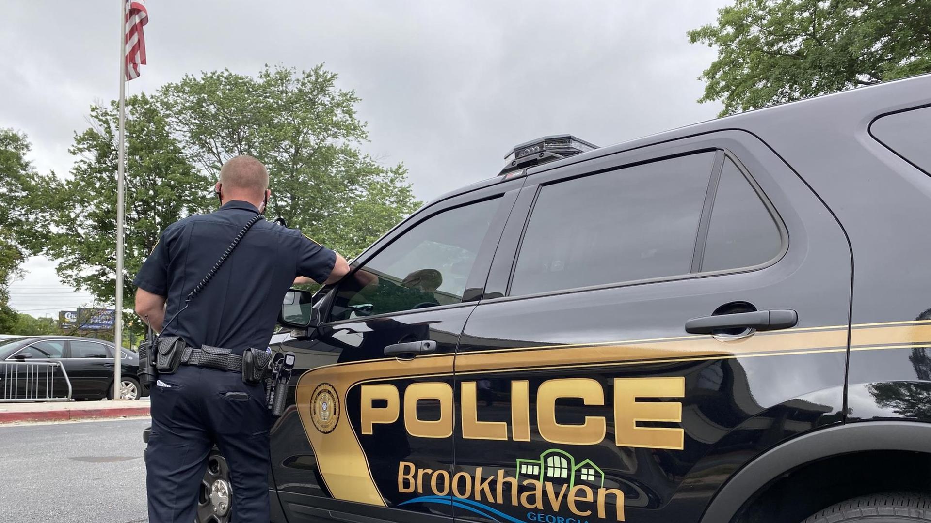 Der US-Polizist Brian Vaughan steht neben seinem Polizeiauto, er wendet der Kamera den Rücken zu Der US-Polizist Brian Vaughan steht neben seinem Polizeiauto, er wendet der Kamera den Rücken zu