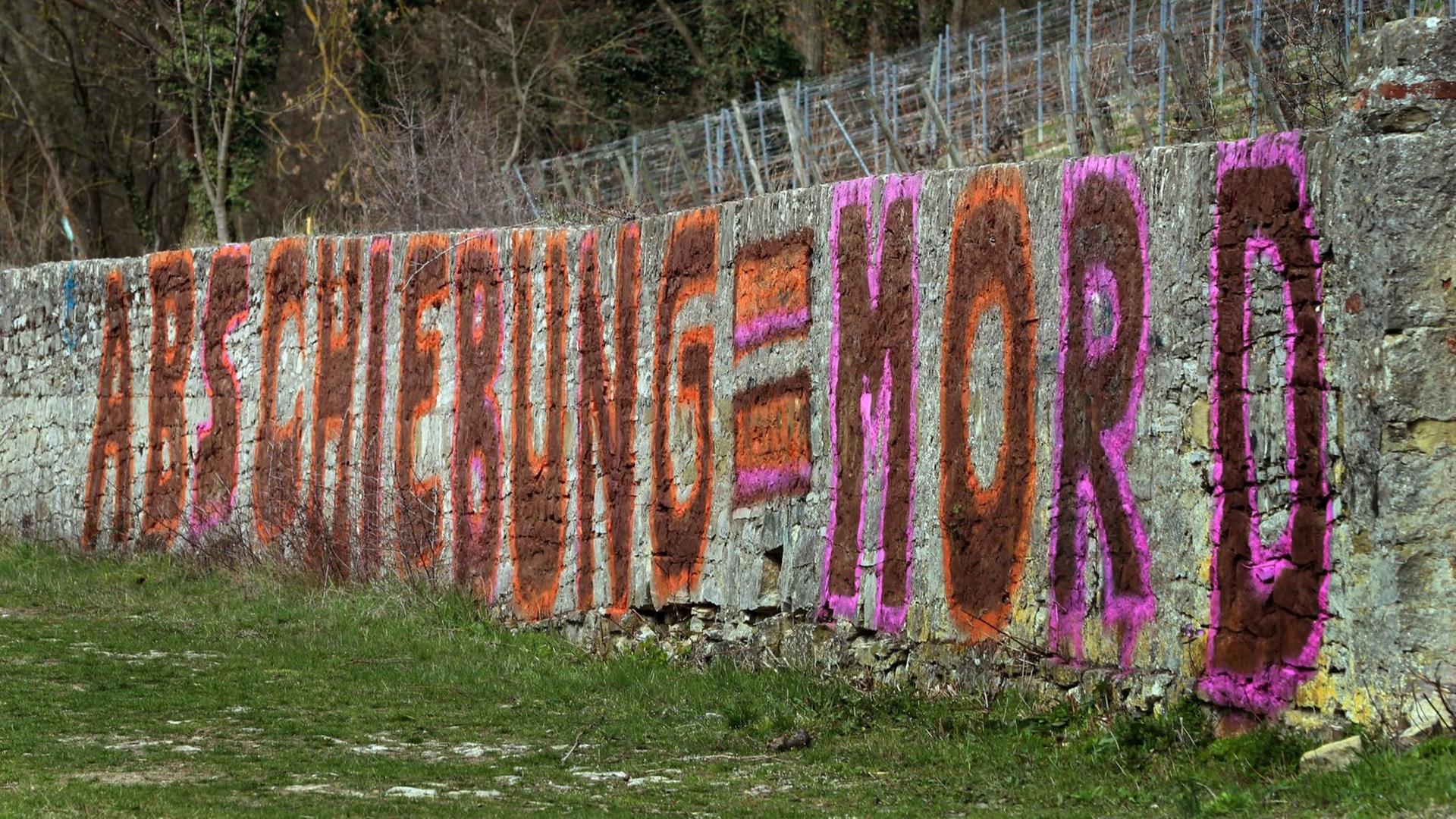 Ein Graffiti mit dem Text "Abschiebung = Mord" ist an einer Weinbergsmauer in Würzberg, Bayern zu sehen. Die Kriminalpolizei ermittelt gegen die unbekannten Täter, die in einer Pressemitteilung ihre Aktion begründeten. Ein Graffiti mit dem Text "Abschiebung = Mord" ist an einer Weinbergsmauer in Würzberg, Bayern zu sehen. Die Kriminalpolizei ermittelt gegen die unbekannten Täter, die in einer Pressemitteilung ihre Aktion begründeten.