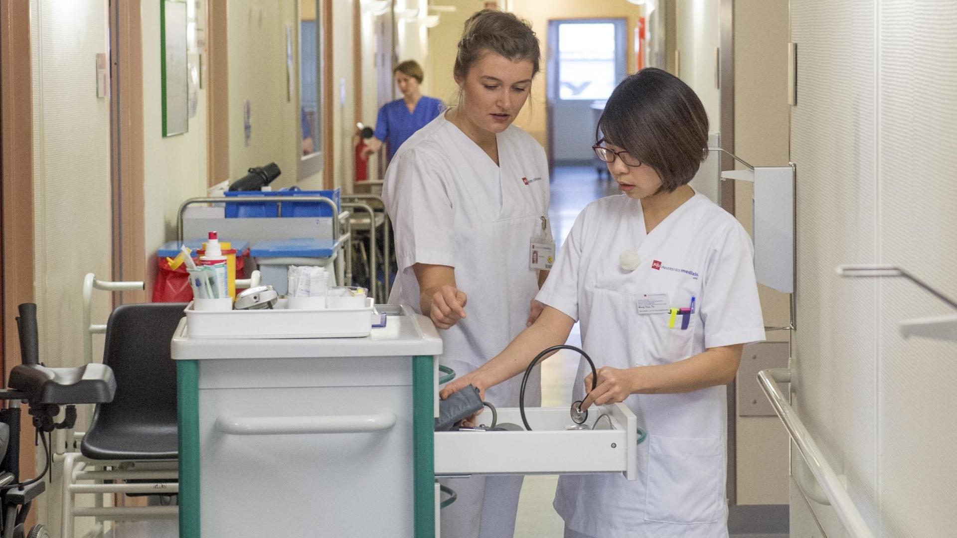Die vietnamesische Projektteilnehmerin Mong Thuy To (r) steht am 11.01.2018 neben Praxisanleiterin Alina Wulf auf der Station der Abteilung für Geriatrie am Zentrum für Allgemeinmedizin und Geriatrie der Universitätsmedizin Mainz, um die Dokumentation von Patientenuntersuchungsdaten kennenzulernen (11.1.2018). Die vietnamesische Projektteilnehmerin Mong Thuy To (r) steht am 11.01.2018 neben Praxisanleiterin Alina Wulf auf der Station der Abteilung für Geriatrie am Zentrum für Allgemeinmedizin und Geriatrie der Universitätsmedizin Mainz, um die Dokumentation von Patientenuntersuchungsdaten kennenzulernen (11.1.2018).