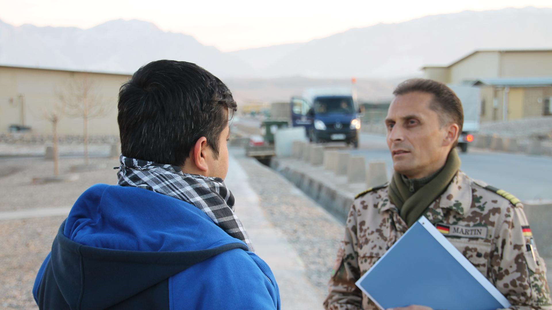 Afghanischer Helfer im Gespräch mit Bundeswehrangehörigem. Afghanischer Helfer im Gespräch mit Bundeswehrangehörigem.