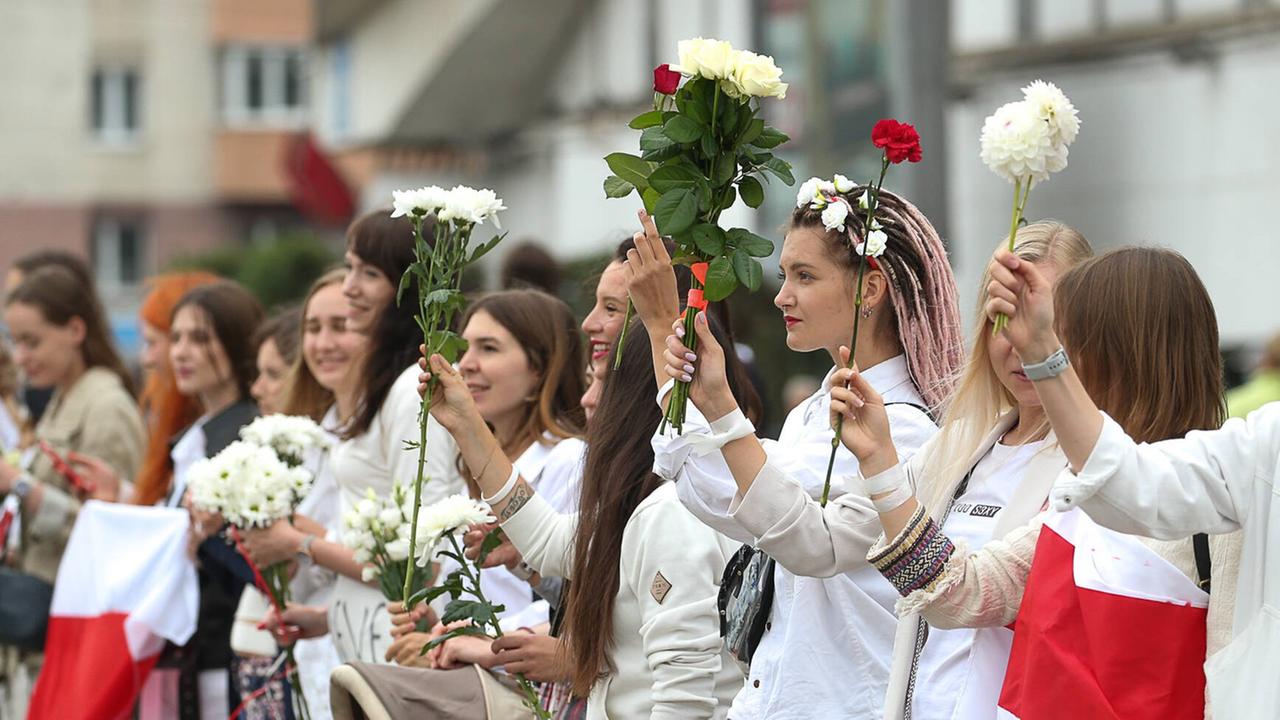 Frauen halten Blumen als Protest in die Luft bei einer Demonstration in der belarussischen Hauptstadt Minsk, am 22. August 2020. Frauen halten Blumen als Protest in die Luft bei einer Demonstration in der belarussischen Hauptstadt Minsk, am 22. August 2020.