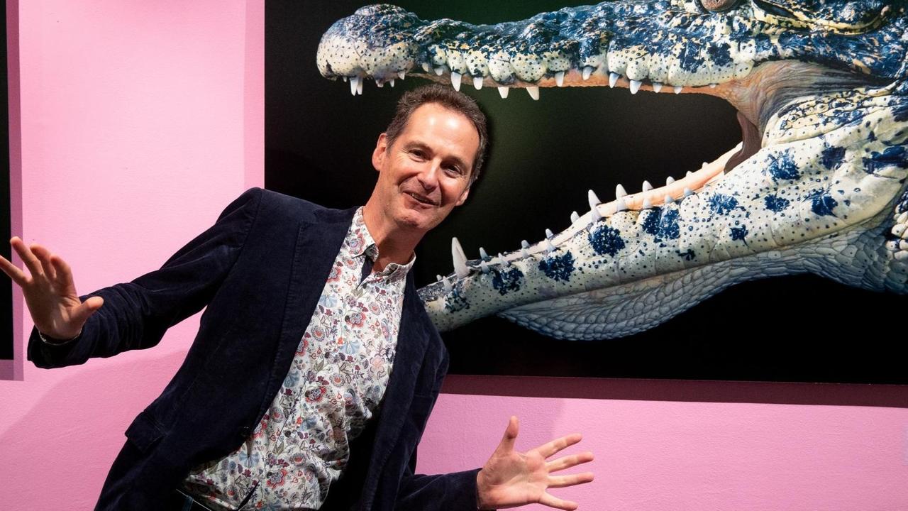 Der britische Tierfotograf Tim Flach bei einer seiner Ausstellungen in Moskau (2018). Er steht vor der Aufnahme eines Krokodils.
