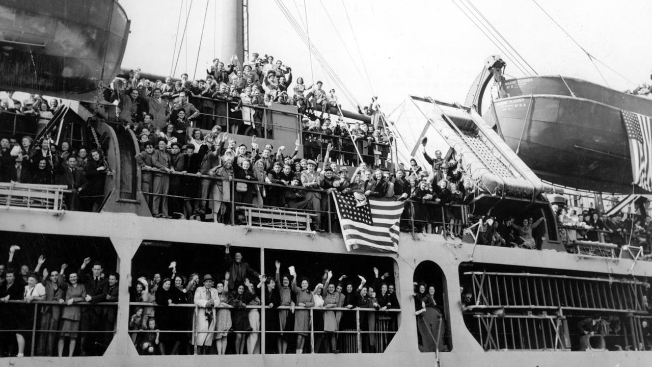 Sogenannte Displaced Persons auf dem US-Transporter "Marine Flasher" winken beim Auslaufen des Schiffs am 10. Mai 1946 in Bremerhaven zum Abschied. Sie konnten im Rahmen des US-Einwanderungsprogramms in die Vereinigten Staaten auswandern.