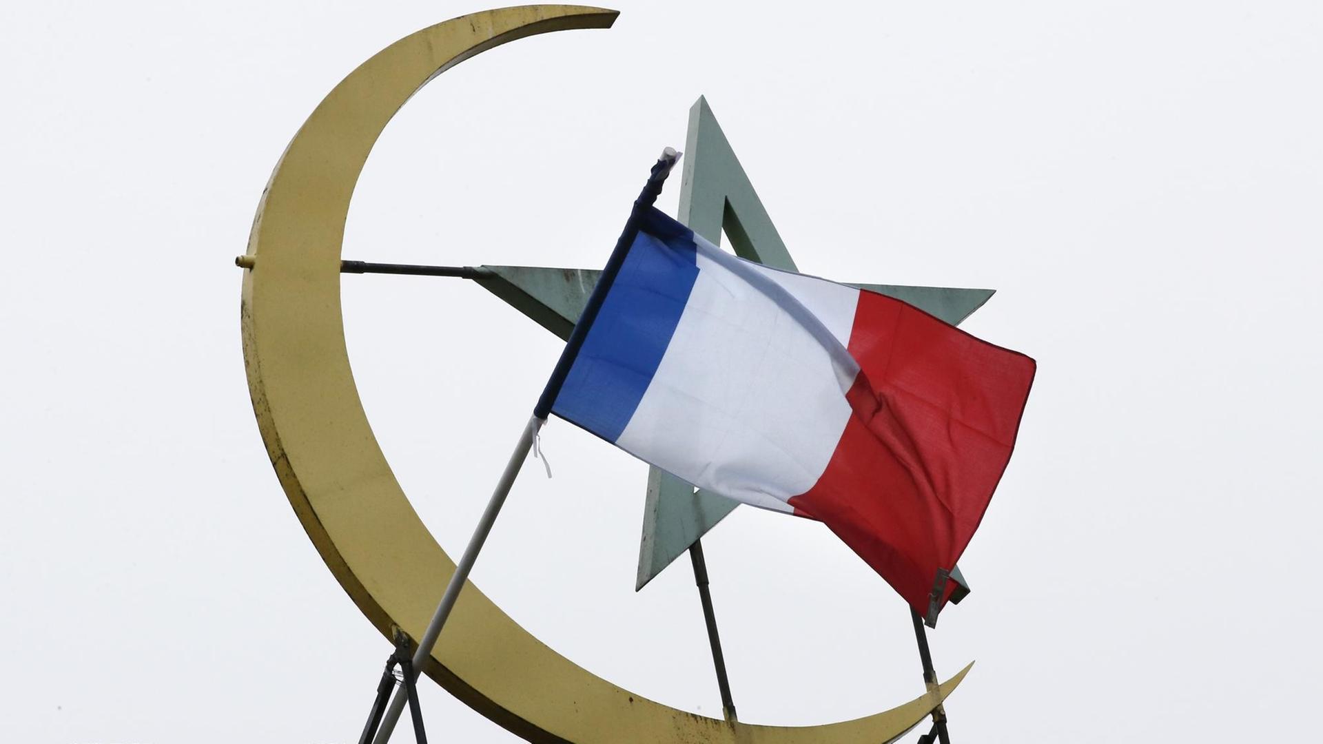 Vor dem islamischen Halbmond und Stern weht die französische Flagge. Vor dem islamischen Halbmond und Stern weht die französische Flagge.
