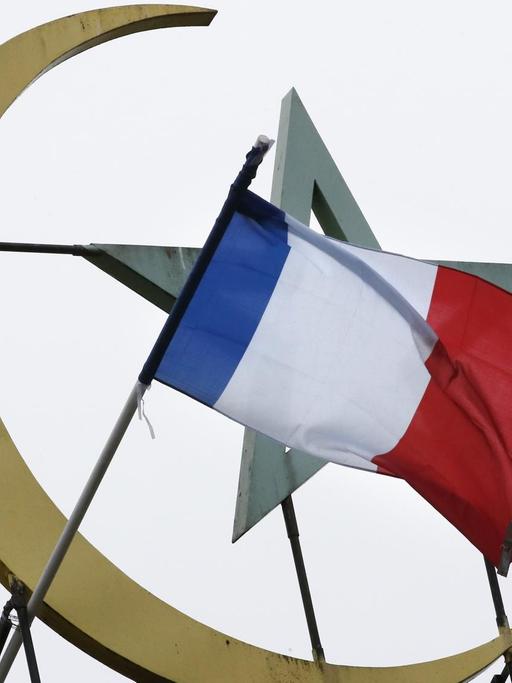 Vor dem islamischen Halbmond und Stern weht die französische Flagge.