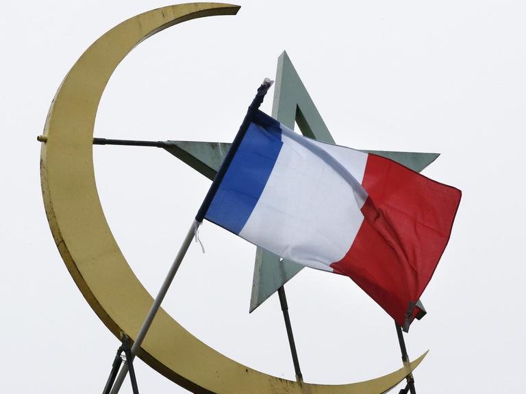 Vor dem islamischen Halbmond und Stern weht die französische Flagge.